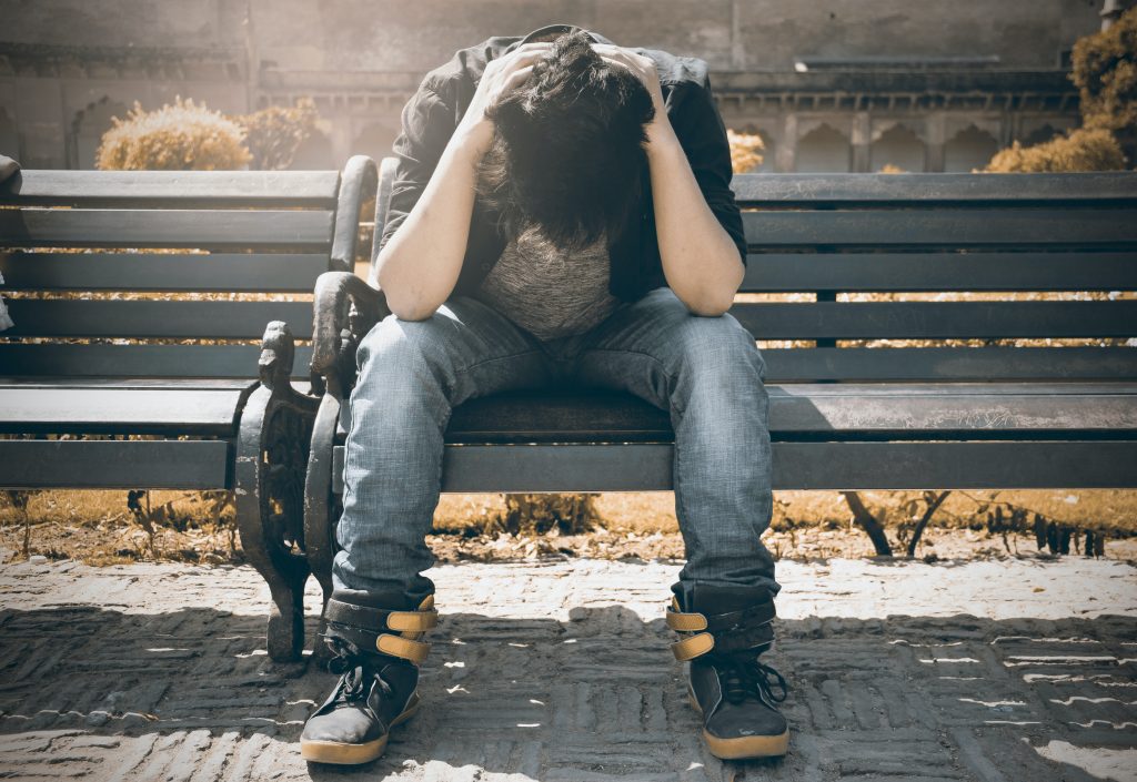 man in black shirt and gray denim pants sitting on gray 1134204 scaled