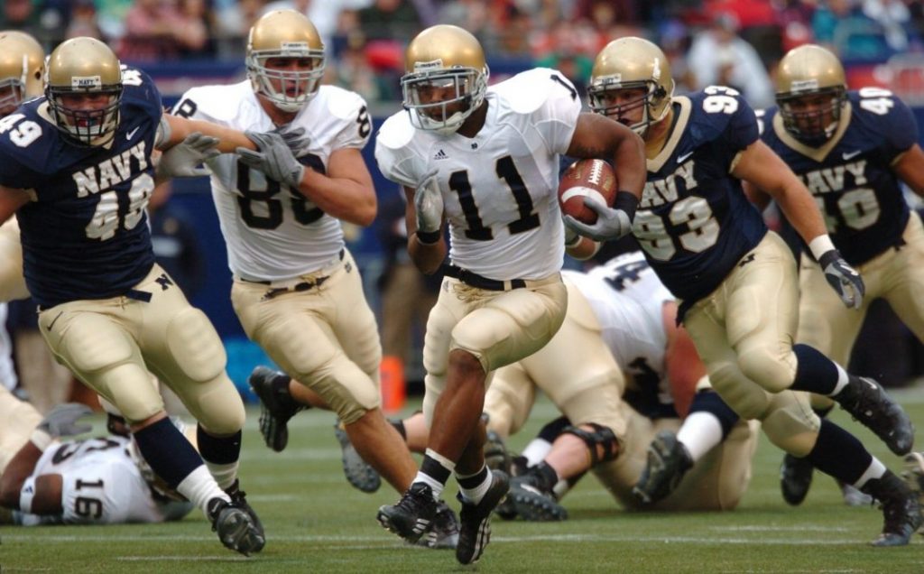 group of male football players running on field during day 163449 scaled