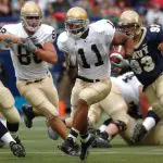 group of male football players running on field during day 163449 scaled