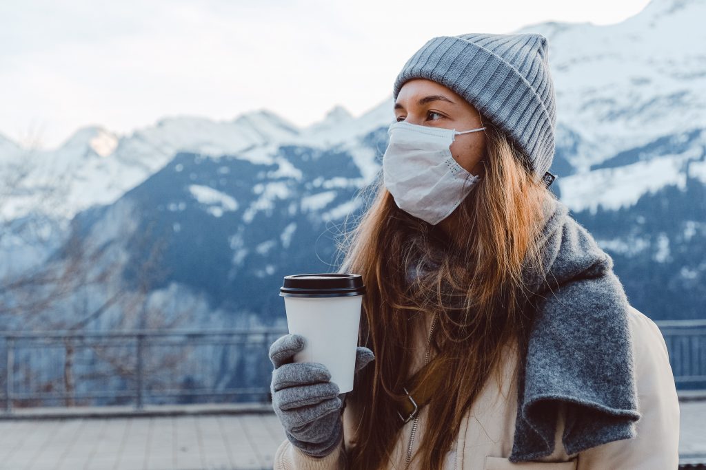 woman in gray knit cap holding white disposable cup 3962265 scaled