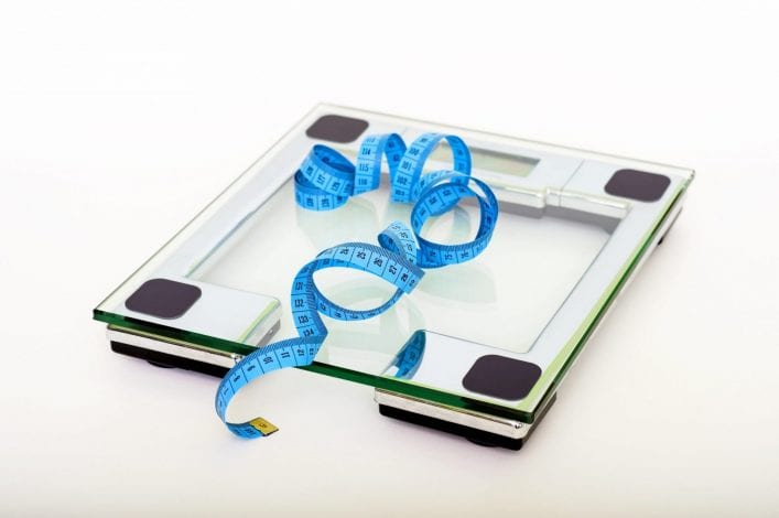 blue tape measuring on clear glass square weighing scale 53404 scaled