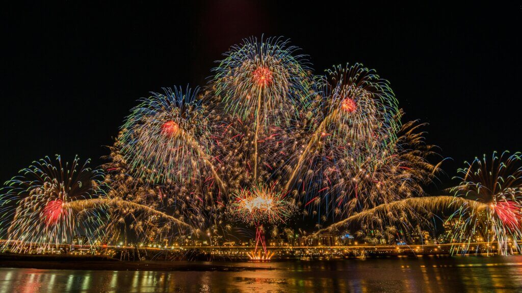 Vibrant fireworks lighting up the night sky in a stunning celebration over Taipei's waterfront.